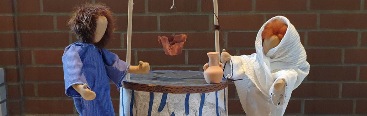 Ein Bild von den Kinderbibeltagen"Gib mir zu trinken". Das Bild zeigt die Samariterin am Brunnen als Jesus sie um Wasser bittet, gestaltet mit biblischen Erzählfiguren