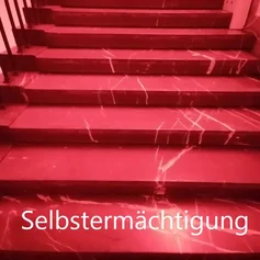 rote Treppenstufen mit Schrift auf unterster Stufe: Selbsermächtigung