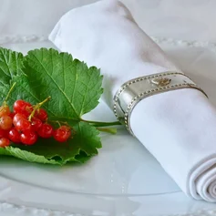 Serviette und Blatt mit Beeren auf einem Glasteller