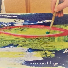 Hand hält Pinsel und malt