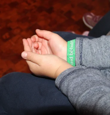 Eine Person hält die beiden Hände vor sich zu einem Gefäß geformt vor sich auf dem Schoß